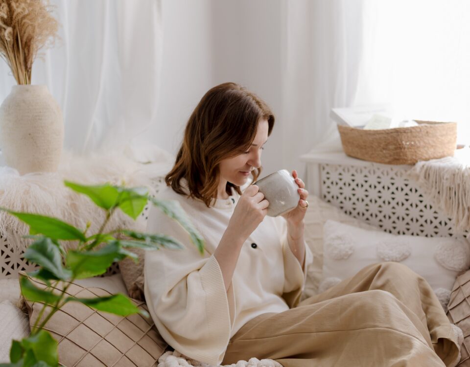 Femeie savurând o băutură caldă într-un interior luminos – Ce este slow living