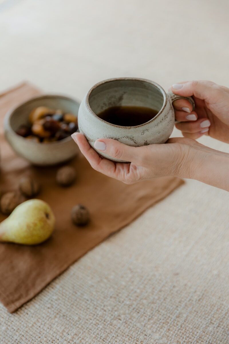 Mâini ținând o cană ceramică – Ritualurile dimineții AYOA